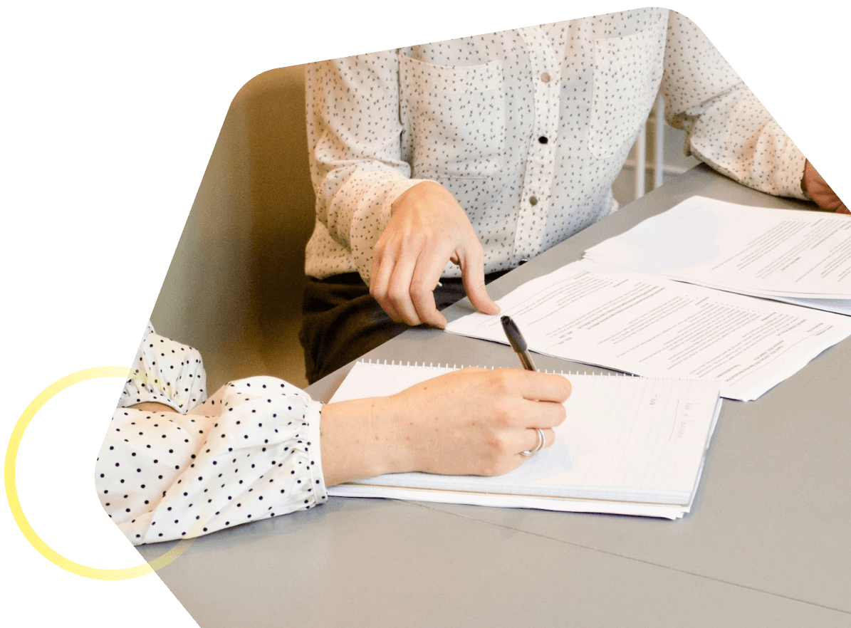 Une personne signe des documents légaux sur un bureau